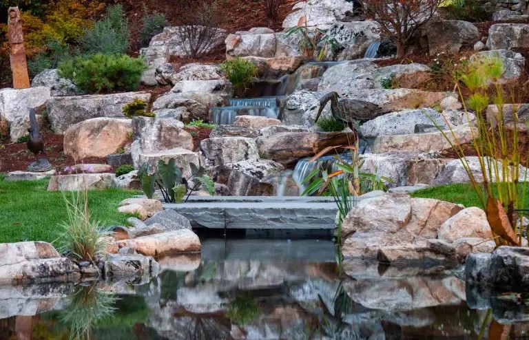 Custom pondless waterfall with natural rock placement and surrounding foliage