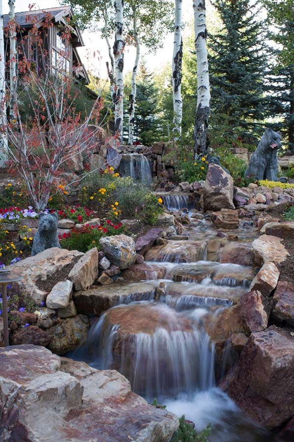 Pondless recirculating waterfall stream over natural rocks with no open pond